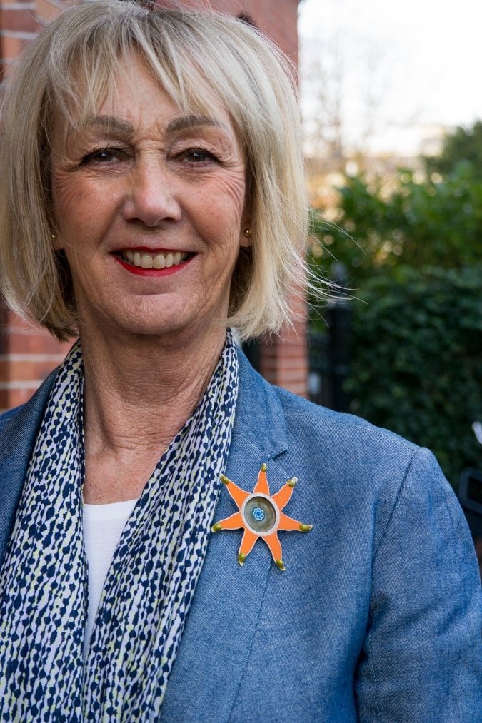Denim jacket with orange brooch