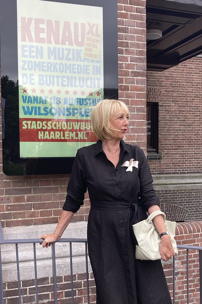 Black linen dress with golden brooch by Claudia Roskam