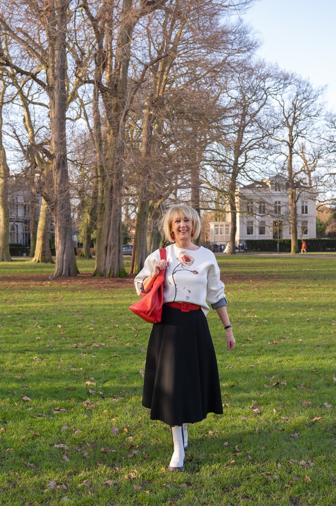 Flared black midi skirt styled in a modern way