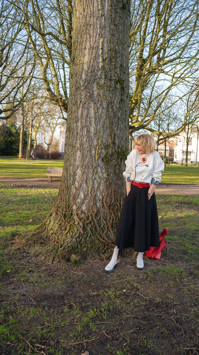 Flared black midi skirt styled in a modern way