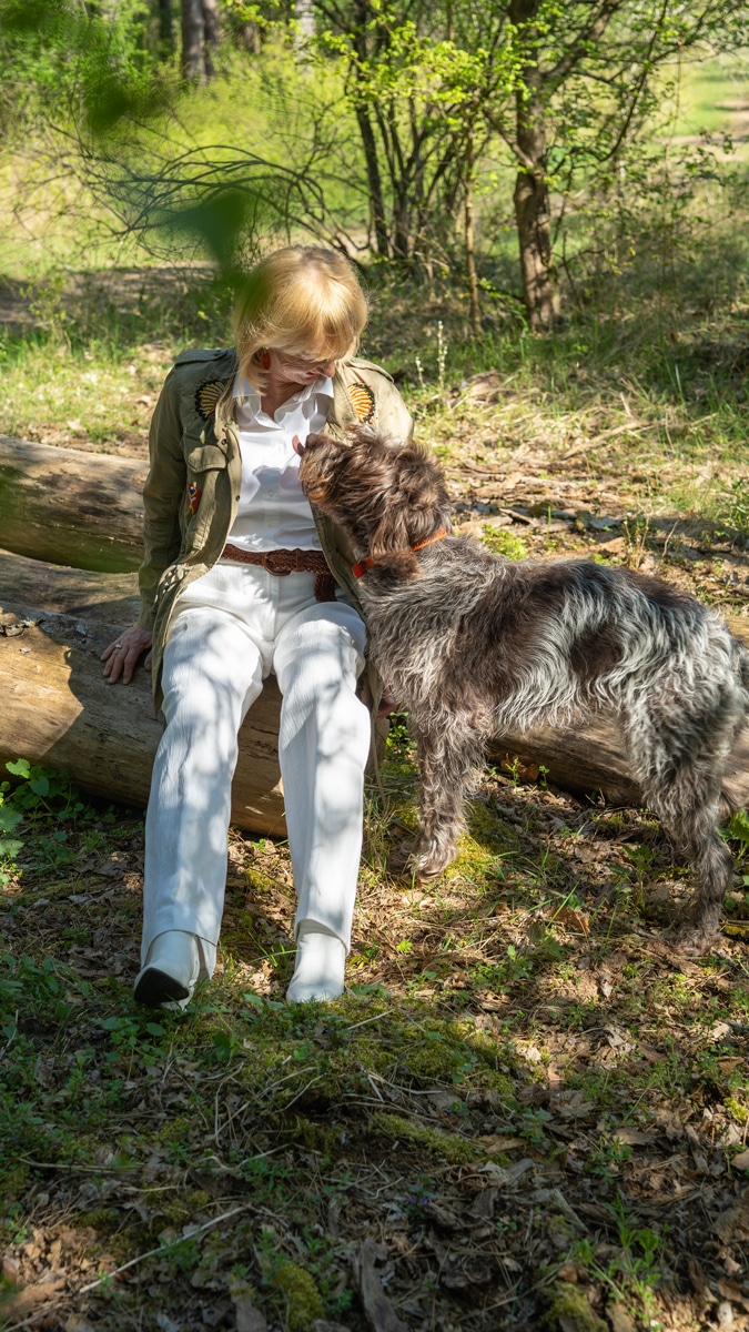 White trousers and shirt with a green jacket