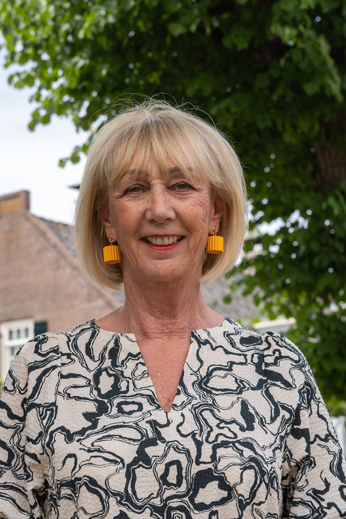 Long black and cream dress with yellow cardboard earrings