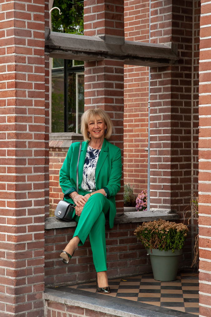 Green suit with blue, silver, white blouse and silver pumps
