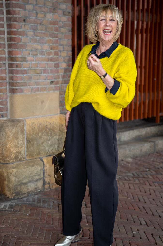 Wide black trousers and a big yellow jumper