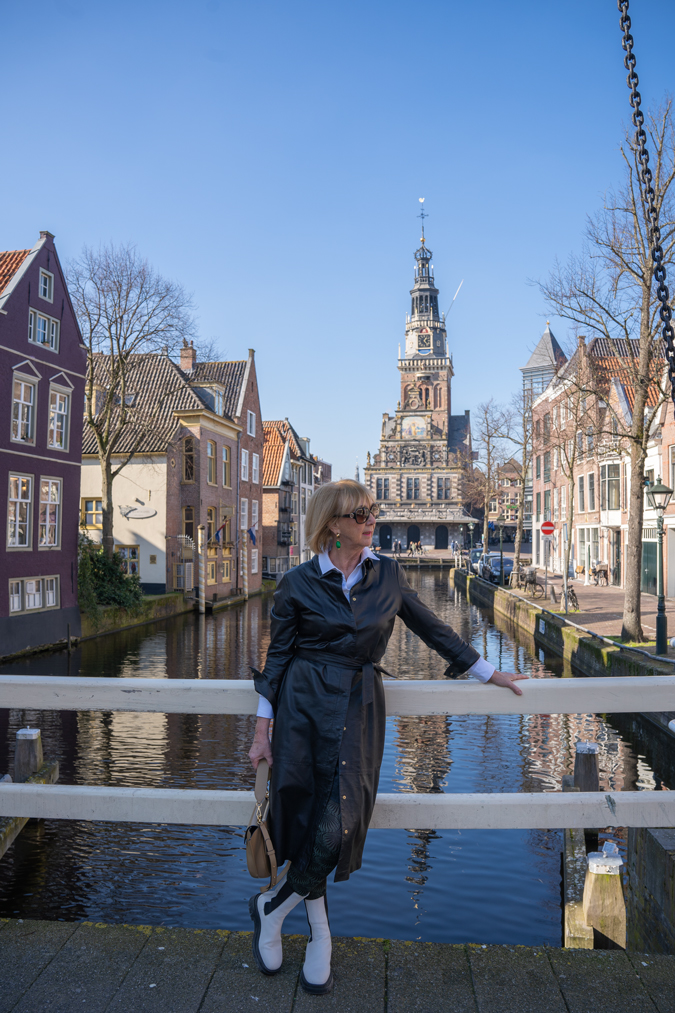 Black leather dress with combat boots and green earrings by Lara Design