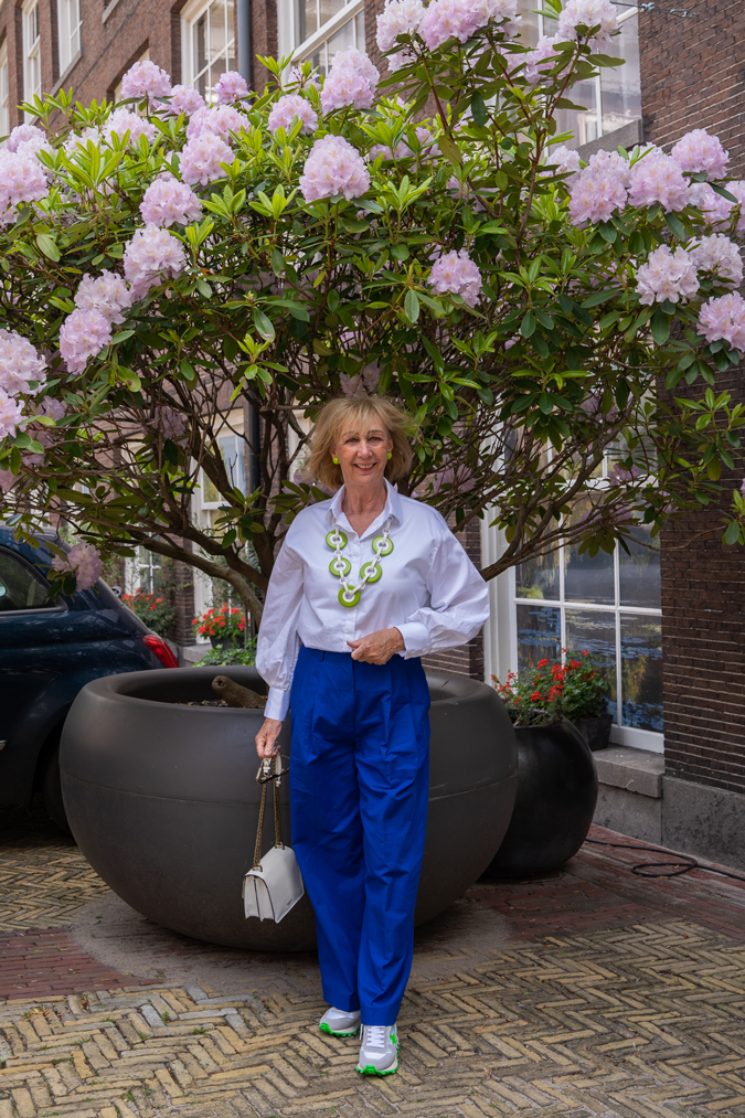 Cobalt blue trousers with green and white necklace by Angela Caputi