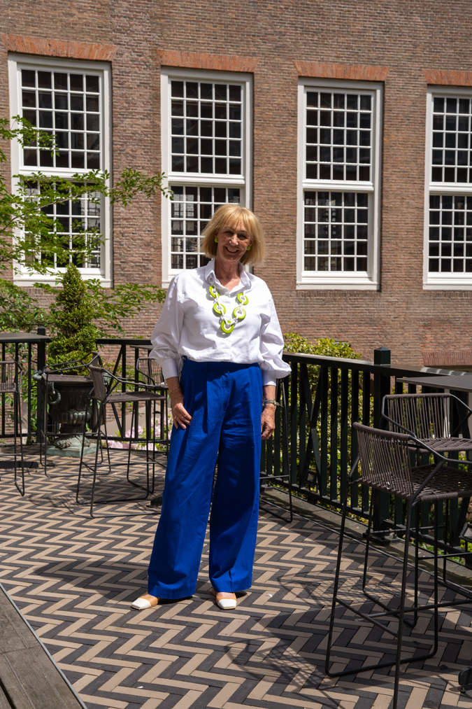 Cobalt blue trousers with green and white necklace by Angela Caputi
