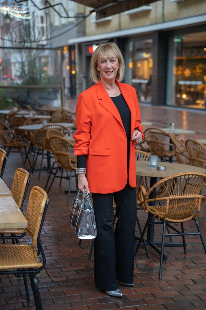 Flared black trousers with an orange blazer