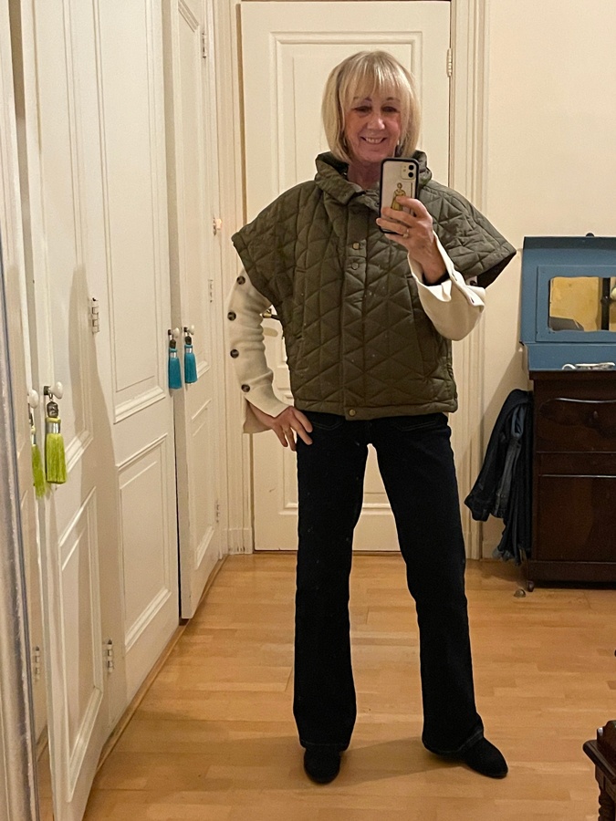 Flared jeans with a cream jumper and a puffer vest