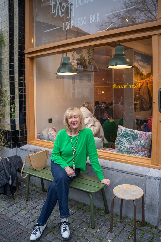 green jumper with flared jeans and trainers