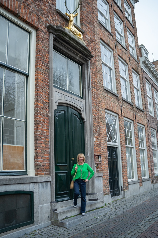 green jumper with flared jeans and trainers