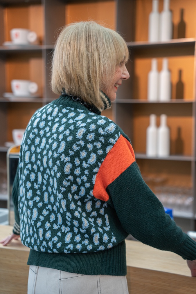 Green jumper with cream trousers