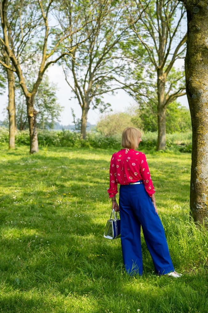 Bright blue trousers with a bright pink blouse