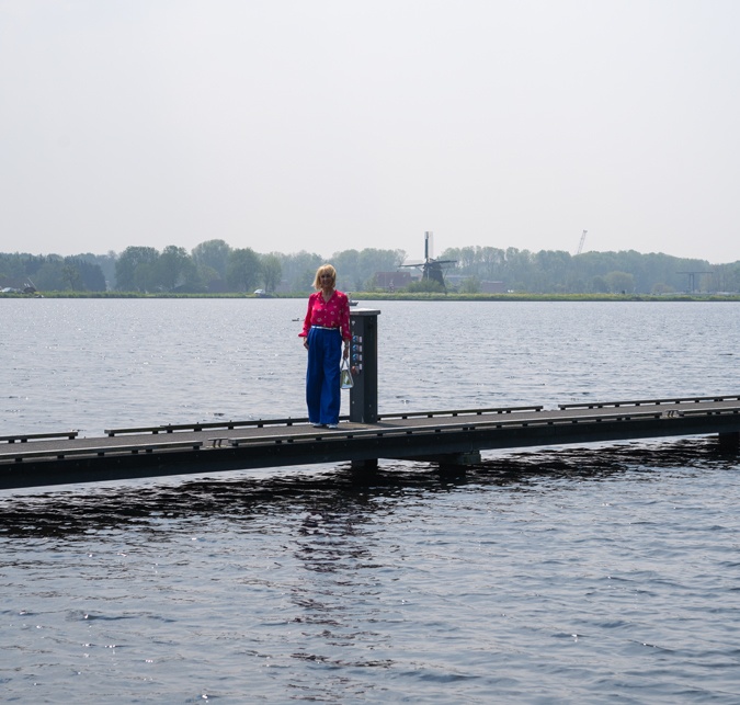 Bright blue trousers with a bright pink blouse