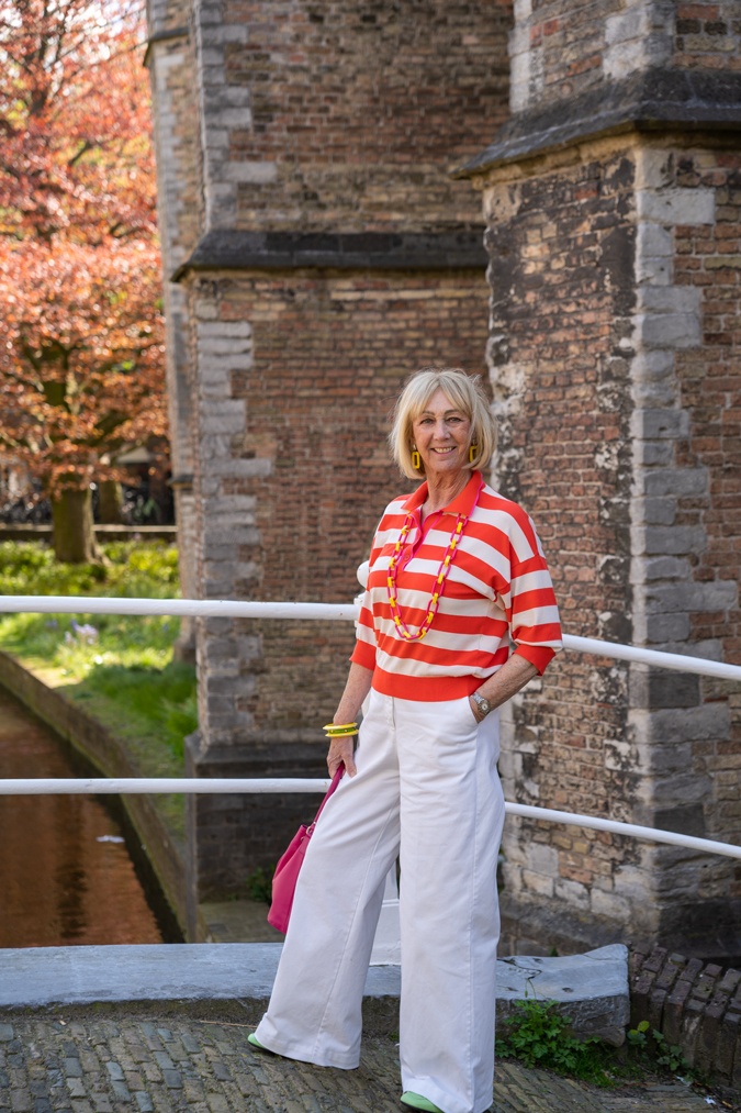 Wide white trousers with orange and pink polo shirt