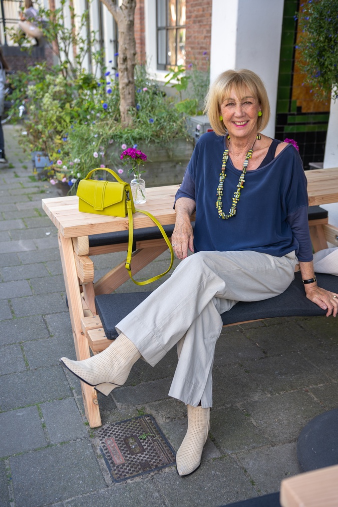 Pebble coloured trousers with a colourful necklace