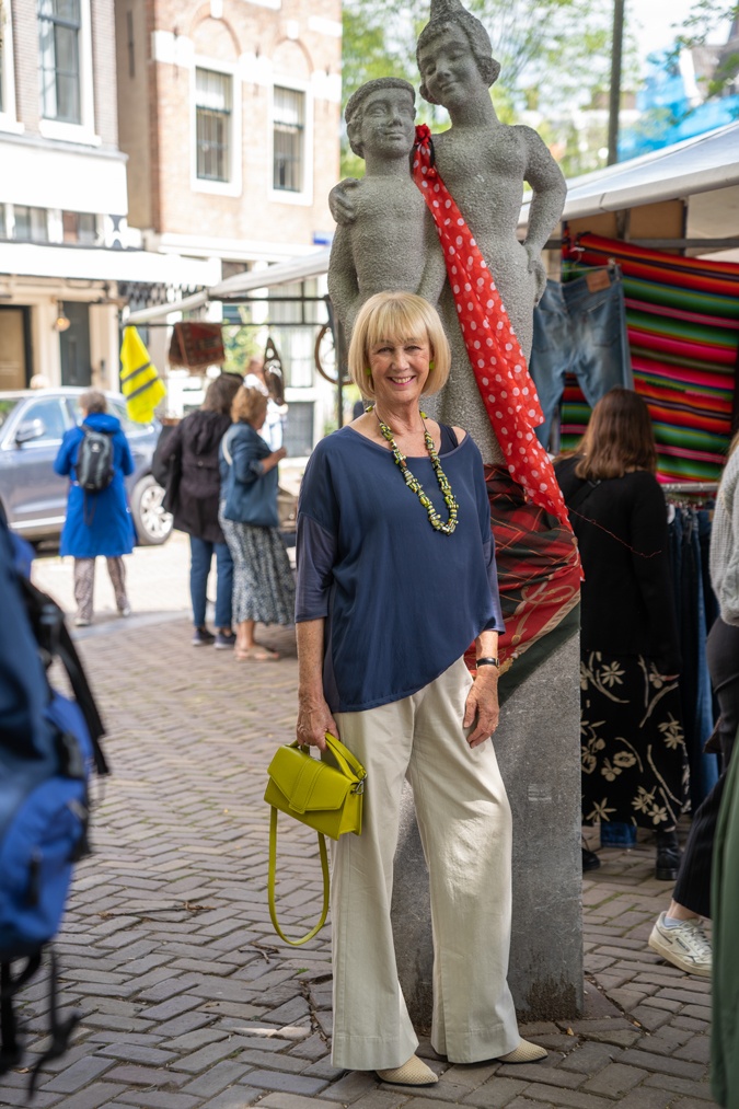 Pebble coloured trousers with a colourful necklace
