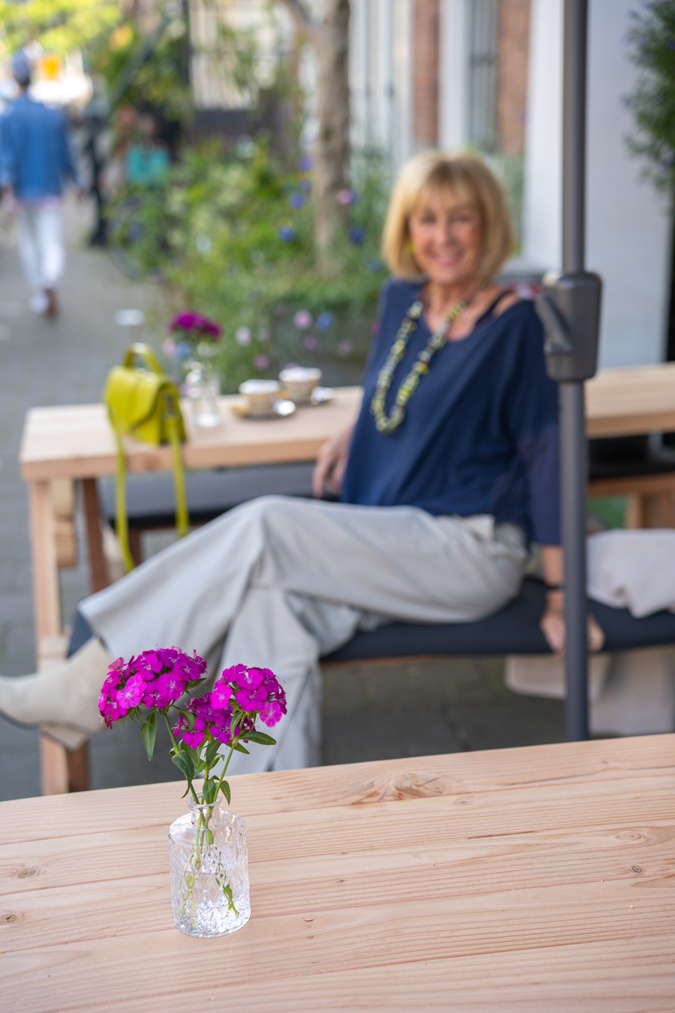 Pebble coloured trousers with a colourful necklace