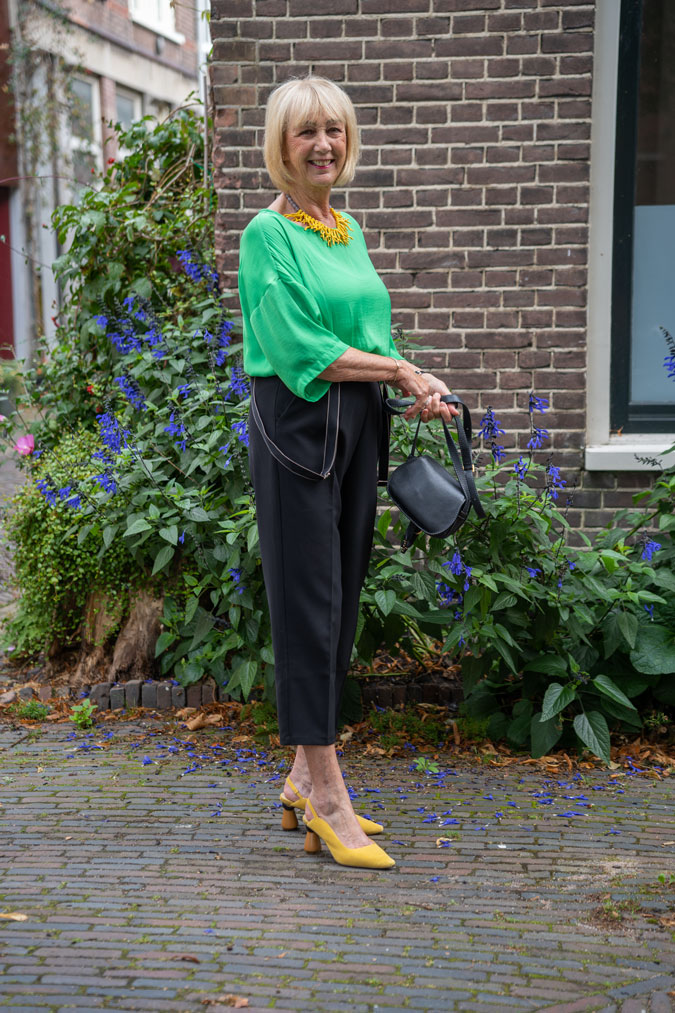 Black summer trousers with a green top and yellow necklace