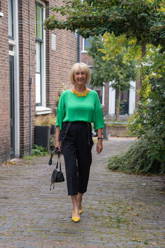 Black summer trousers with a green top and yellow necklace