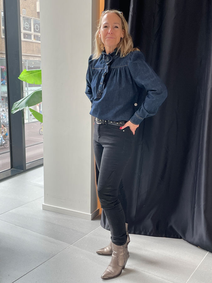 Sabine trying on a dark denim shirt