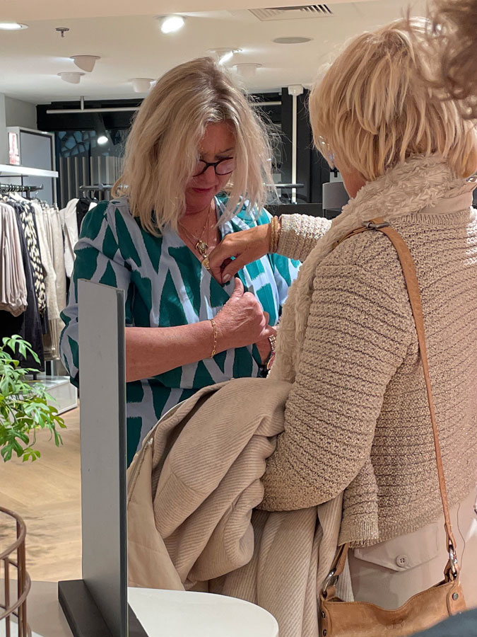 Marijke helping Jilske trying on a dress