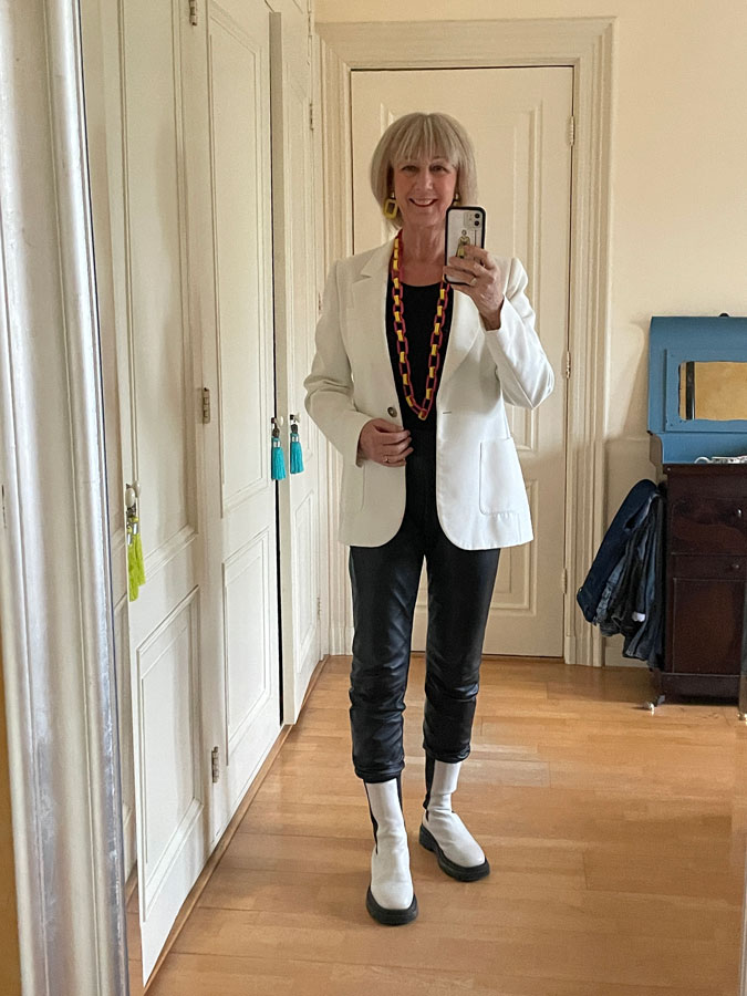 Black leather jogging trousers with white blazer and colourful necklace