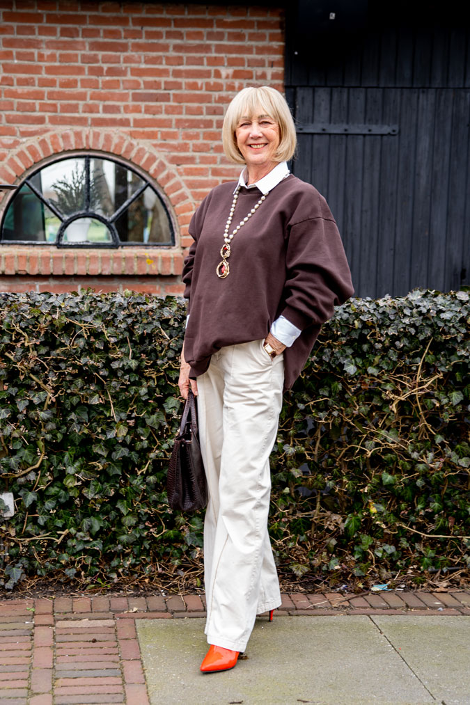 Brown oversized sweater with wide leg cream trousers