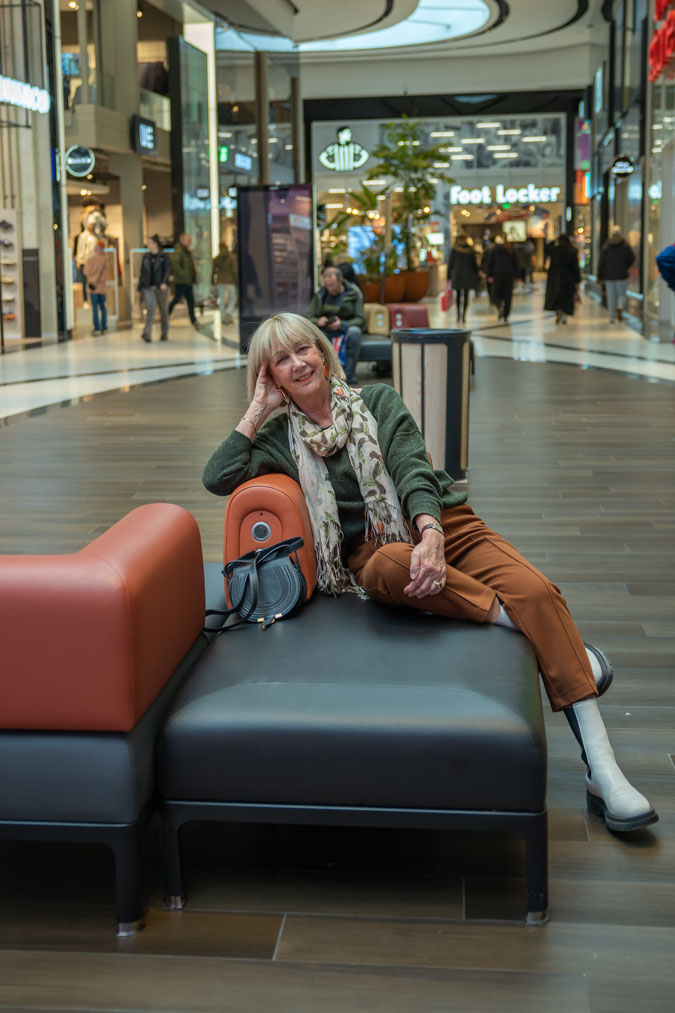 Cognac coloured trousers with a green jumper and a scarf
