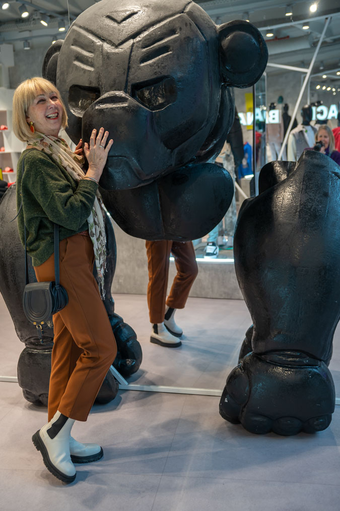 Cognac coloured trousers with a green jumper and a scarf