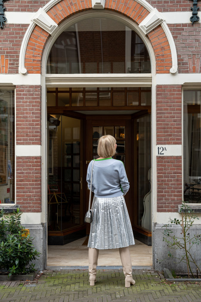 Silver skirt with a green jumper that has a blue back