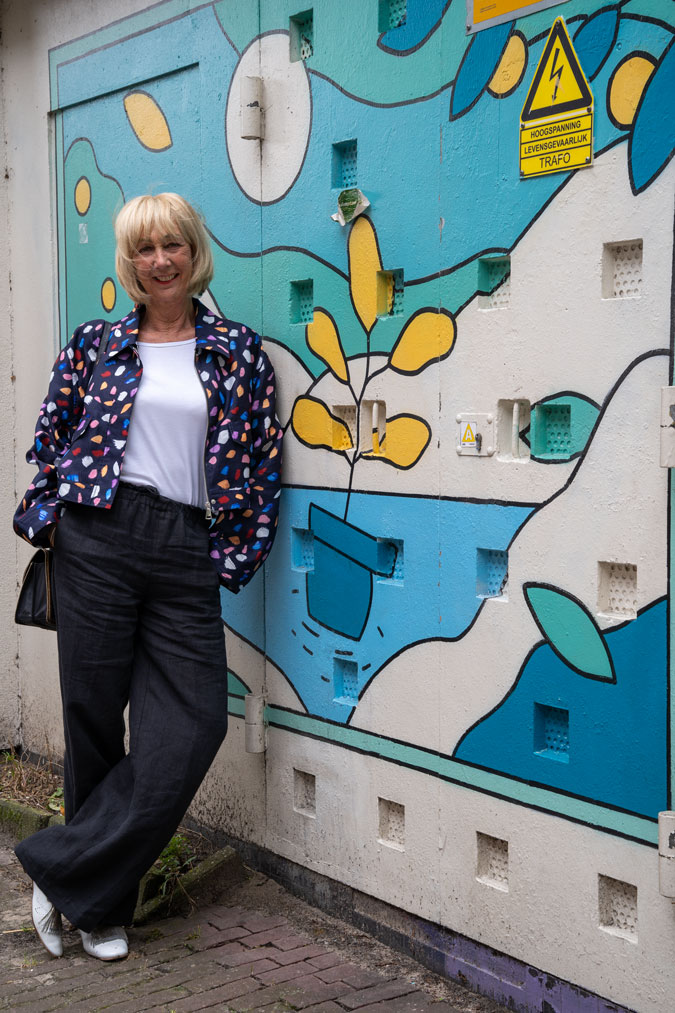 Multicoloured jacket against mural by Erwin Verkade