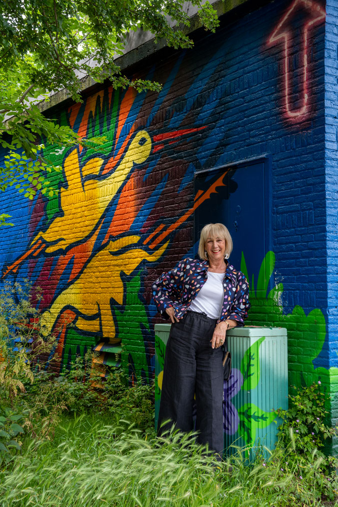 Multicoloured jacket against mural by Jochem Cats and Roelof Schierbeek