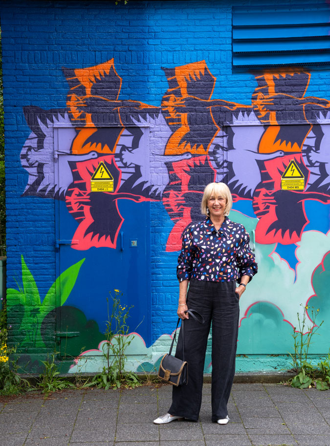 Multicoloured jacket against mural by Jochem Cats and Roelof Schierbeek