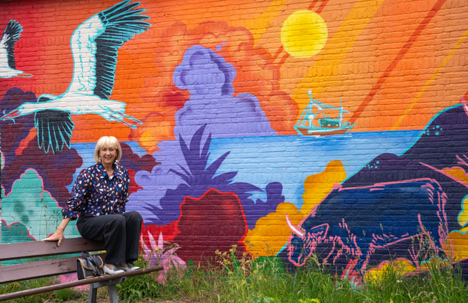 Multicoloured jacket against mural by Jochem Cats and Roelof Schierbeek