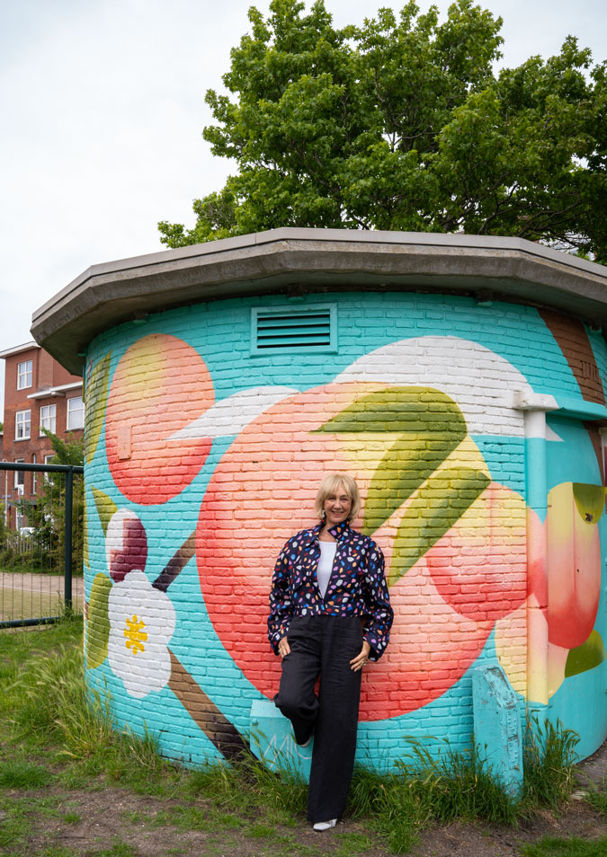 Multicoloured jacket against mural by Micha de Bie