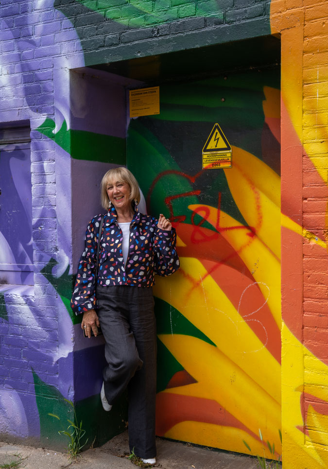 Multicoloured jacket against mural by Roelof Schierbeek and Patrick IJmkers