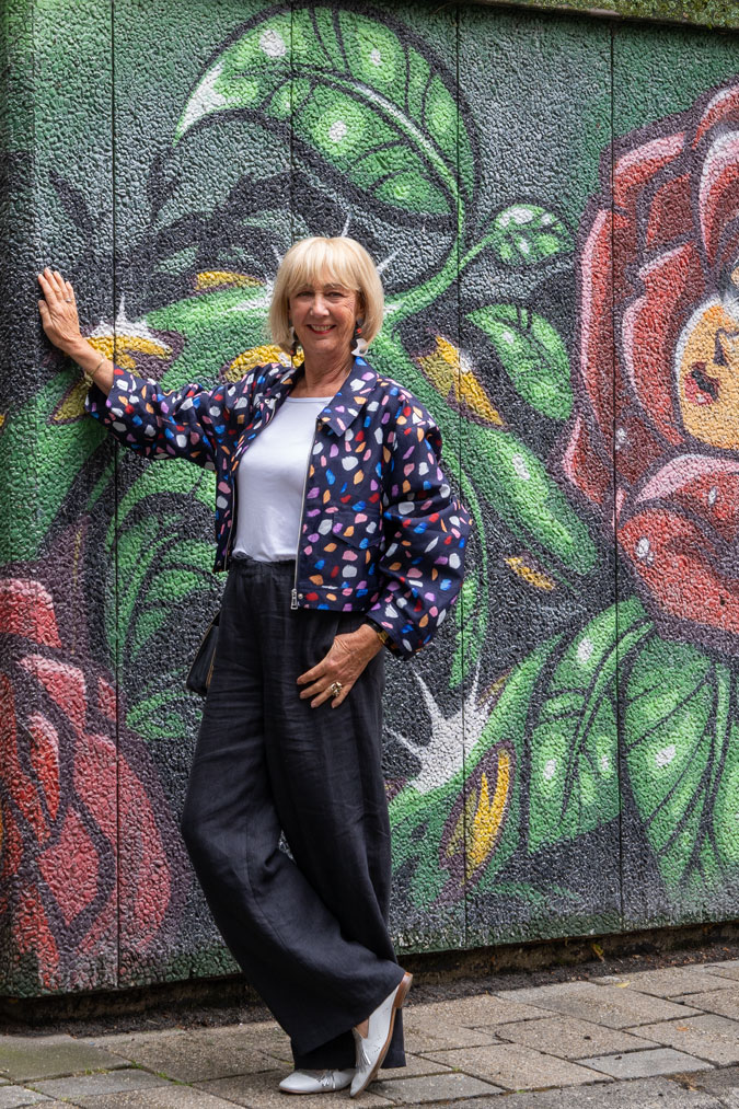 Multicoloured jacket against mural by Sergio Andrea