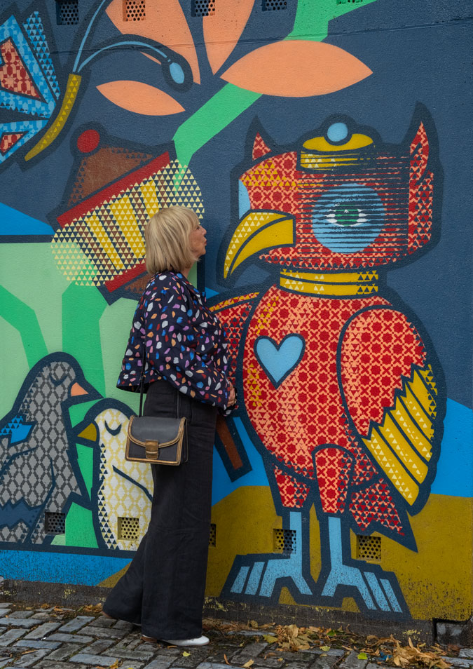 Multicoloured jacket against mural