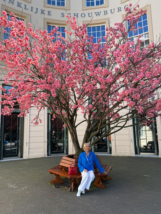White trousers with a bright blue top and pearls