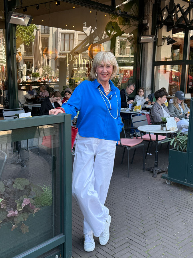 White trousers with a bright blue top and pearls