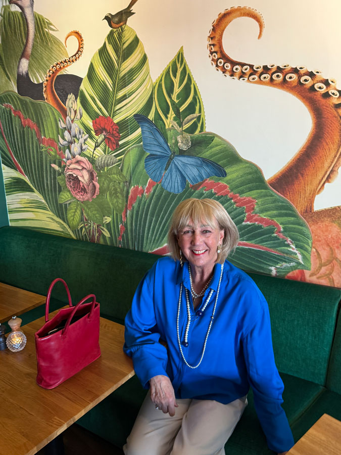 White trousers with a bright blue top and pearls