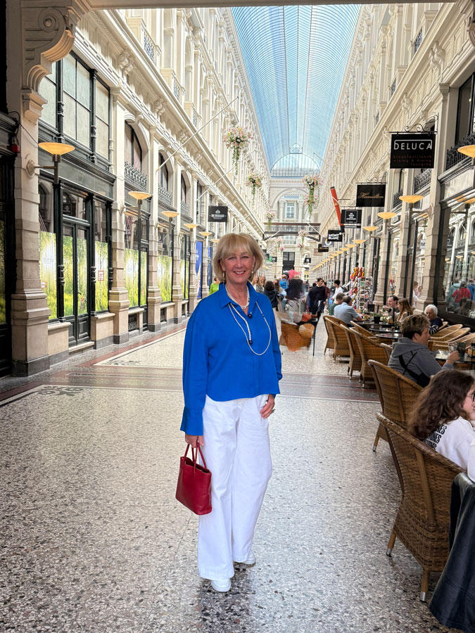White trousers with a bright blue top and pearls
