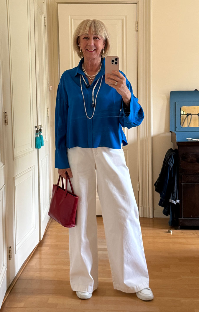 White trousers with a bright blue top and pearls