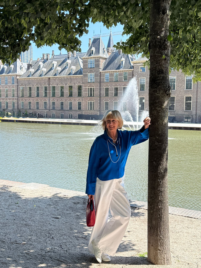 White trousers with a bright blue top and pearls