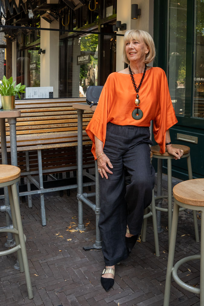 Black linen trousers with an orange top