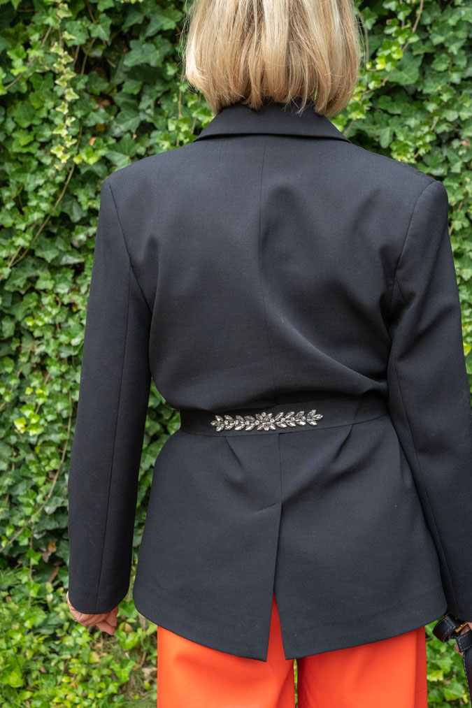 Pleated black blazer with orange pleather trousers