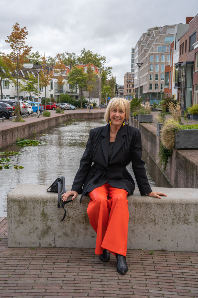 Pleated black blazer with orange pleather trousers